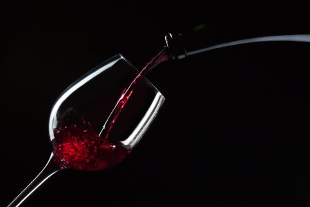 bottle and glass with red wine on  black background